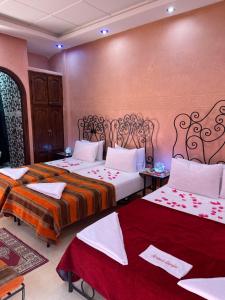 a bedroom with two beds with red and orange blankets at Riad Afriquia Garden in Marrakesh +67 photos