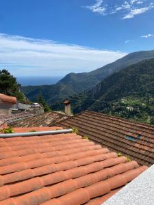a roof of a house with mountains in the background at LE PANORAMIC- Sainte Agnès in Sainte-Agnès