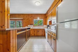 a kitchen with wooden cabinets and a refrigerator at Cabin #5 3BR 2BA Timberlane Resort in Park Rapids