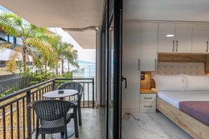 a bedroom with a balcony with a bed and a table at Mirage Bay Deluxe in Sarandë
