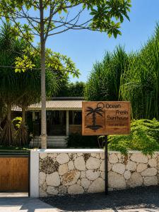 a sign in front of a resort with a sign at Ocean Fresh Surfhouse in Pulau Sarang