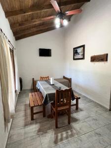 a dining room with a table and a ceiling fan at Cabañas El Campo in Sierra de la Ventana