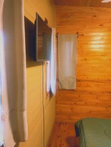 a room with a television and a bed and a window at Refugio La Lechuza in San Rafael