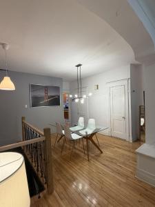 a dining room with a table and white chairs at Verdun Beach, House in Montreal