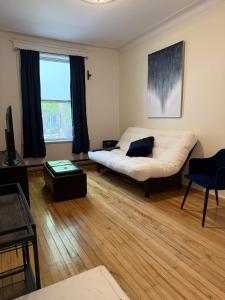 a living room with a bed and a couch and a window at Verdun Beach, House in Montreal