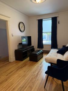 a living room with a couch and a clock on the wall at Verdun Beach, House in Montreal