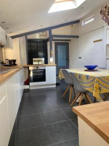 a kitchen with a table and some chairs and a table and a counter at LE PANORAMIC- Sainte Agnès in Sainte-Agnès +17 photos