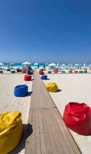 a row ofools on a beach with the ocean in the background at Marseilia Resort in Al Ḩammām