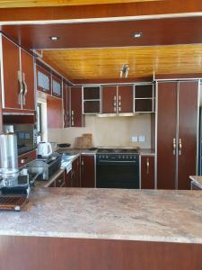 a kitchen with wooden cabinets and a counter top at Khomasdal B&B in Windhoek