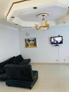 a living room with a couch and a tv on the wall at Khomasdal B&B in Windhoek