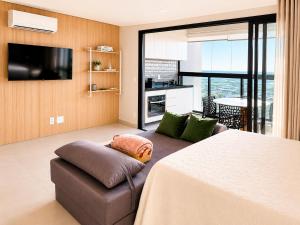 a living room with a couch and a flat screen tv at Studio na Av Esmeraldas com garagem in Marília