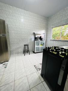 a kitchen with a stove and a table in it at Recanto Tranquilo - Espaço amplo e completo - Sky in São Luís