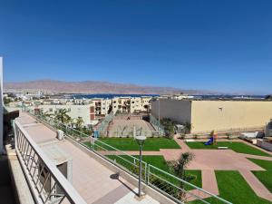 a balcony with a view of a park and buildings at Lev Eilat Suites in Eilat