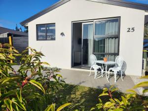 a house with a table and chairs in front of it at Riverside retreat, Wanaka in Albert Town