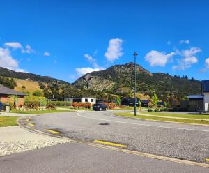 an empty road with a mountain in the background at Riverside retreat, Wanaka in Albert Town +10 photos