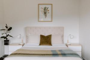 a bedroom with a large white bed with two lamps at Riverside retreat, Wanaka in Albert Town