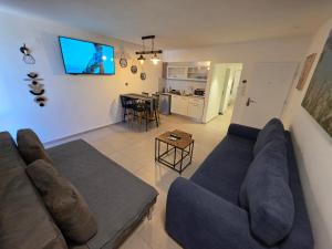 a living room with a couch and a tv on the wall at Lev Eilat Suites in Eilat