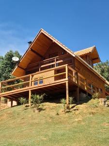a large wooden house on top of a hill at Chalé Terra Nova in Itamonte