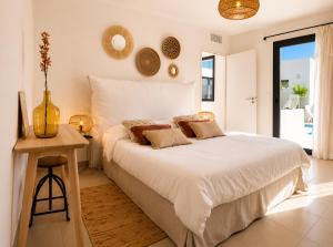 a bedroom with a large white bed and a table at Oasis Blue Perpignan Canet in Perpignan +18 photos
