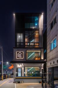 a tall building with a sign on it at night at STAY On-A in Seoul