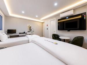 a hotel room with two beds and a flat screen tv at 대구 동천 스위트 호텔 in Daegu