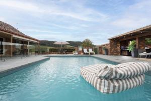 a swimming pool with a chaise lounge in a house at The Cottage-Gather the crew or the family and prepare for fun times and relaxation. Making memories in Yarra Junction