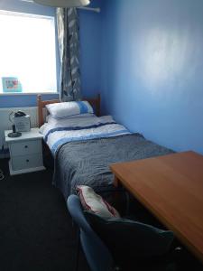 a bedroom with a bed and a desk and a table at Shephall Zoo in Shephall