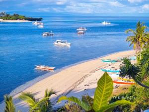 a group of boats in the water on a beach at The Clifftop Home Deluxe in Esperanza