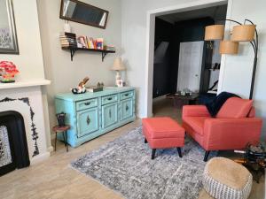a living room with a blue cabinet and a red chair at Vintage Home Vibe in Jersey City