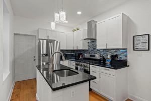 a kitchen with white cabinets and a stainless steel sink at Modern 3BR Home Patio Near Center City Free Parkin in Philadelphia +33 photos