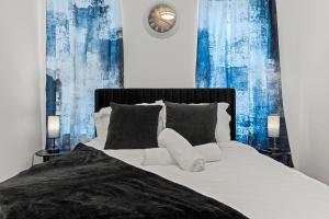 a bedroom with a bed with blue curtains and a clock at Modern 3BR Home Patio Near Center City Free Parkin in Philadelphia