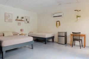 a room with two beds and a table and a chair at Rooms & Pool Macaws in Uvita