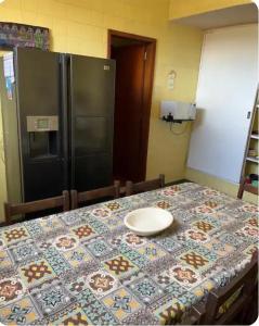 a table with a plate on a table with a refrigerator at Suíte Pimenteiras in Teresópolis