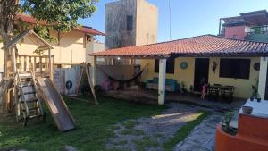 a house with a playground in the yard at Sol guest house in Pipa