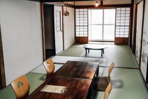 a dining room with a wooden table and chairs at Tipy records inn house in Odawara