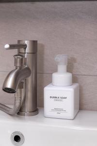 a bathroom sink with a bottle of soap and a faucet at STAY On-A in Seoul +110 photos