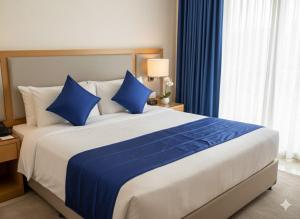 a bedroom with a large bed with blue pillows at Munot residency in Manmād