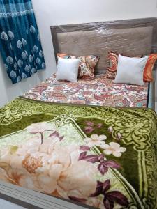 a bed with a bedspread with flowers on it at Munot residency in Manmād