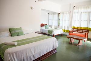 a bedroom with two beds and a chair and window at Bungalows Puerta de Sol in Brisas de Zicatela +18 photos