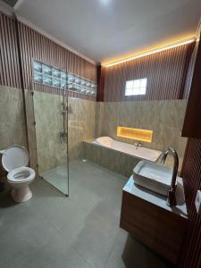 a bathroom with a tub and a toilet and a shower at MEDEWI BREEZE House in Airsatang +20 photos