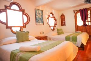 a bedroom with two beds with green and white sheets at Bungalows Puerta de Sol in Brisas de Zicatela
