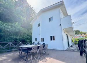 a white house with a table and chairs on a deck at Casa2 in Katsura