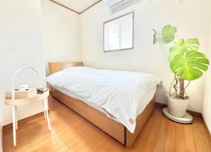 a bedroom with a bed and a potted plant at Casa2 in Katsura