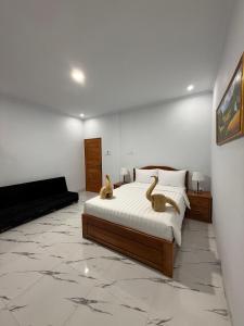 a bedroom with a bed with two animals on it at MEDEWI BREEZE House in Airsatang