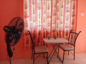 a room with a table and two chairs and a fan at Port Antonio Residence in Port Antonio