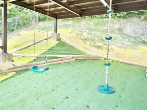 two swings in a building with a green floor at Casa2 in Katsura