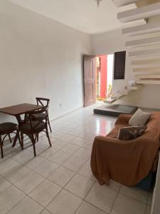 a living room with a bed and a dining room table at Suíte com ampla área externa - Pink in São Luís