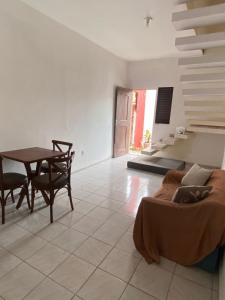 a living room with a table and a bed at Suíte com ampla área externa - Pink in São Luís