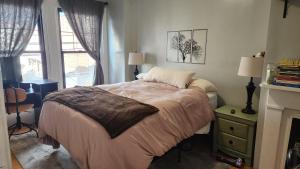 a bedroom with a bed and a fireplace and a window at Vintage Home Vibe in Jersey City