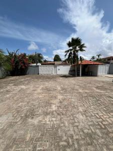 a building with a palm tree in a yard at Recanto Tranquilo - Espaço amplo e completo - Sky in São Luís
